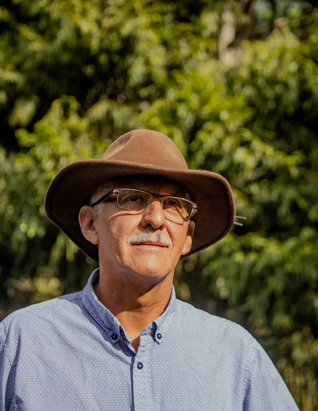 man in gray button up shirt wearing brown fedora hat